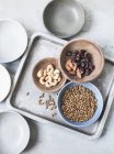Верхний вид различных орехов и семян в мисках — стоковое фото