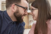 Mid adult man and daughter smiling face to face — Stock Photo