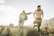 Couple running in field at daytime — Stock Photo
