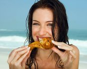 Giovani donne che mangiano una coscia di pollo — Foto stock