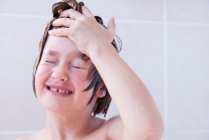 Chica lavándose la cara en el baño - foto de stock