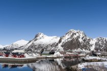 Häuser am Wasser und schneebedeckte Berge, svolvaer, lofoten Inseln, Norwegen — Stockfoto