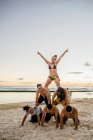 Sechs erwachsene Freunde bilden menschliche Pyramide am Waikiki Beach, Hawaii, USA — Stockfoto