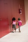 Visão traseira de duas meninas pré-escolares de mãos dadas — Fotografia de Stock