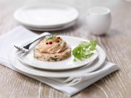 Garnished poached salmon starter with arugula on plate — Stock Photo