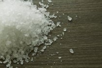Close up of rock salt on wooden surface — Stock Photo