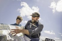 Padre e figlio adolescente in viaggio leggendo la mappa pieghevole, Cody, Wyoming, Stati Uniti — Foto stock