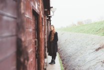 Porträt einer jungen Frau bei verwitterter Hütte — Stockfoto