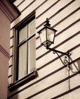 Candeeiro de rua na fachada de edifício na luz solar — Fotografia de Stock
