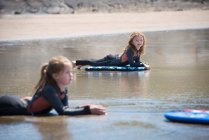 Children on surfboards in water — Stock Photo