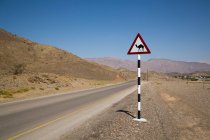 Sinal de passagem de camelo na estrada rural — Fotografia de Stock