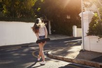 Adolescente con monopatín en la calle, Ciudad del Cabo, Sudáfrica - foto de stock