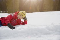 Portrait eines Jungen auf Schnee liegend, Elmau, Bayern, Deutschland — Stockfoto