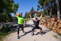 Two young men doing weightlifting training with logs in forest, Split, Dalmatia, Croatia — Stock Photo