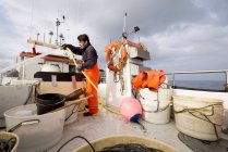 Рыбак поливает рыбацкую лодку — стоковое фото