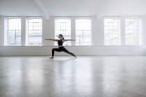 Женщина в танцевальной студии в позе йоги — стоковое фото