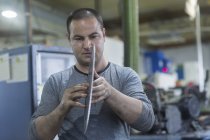 Homme adulte caucasien vérifiant lame rotative dans l'atelier — Photo de stock