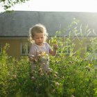Menina jogando em flores — Fotografia de Stock