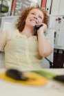 Деловая женщина разговаривает по телефону за столом — стоковое фото