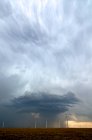 Nubes de tormenta detrás del campo de turbinas eólicas - foto de stock