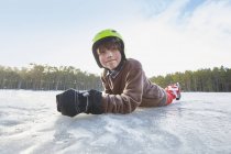Портрет мальчика, лежащего на переднем краю замёрзшего озера, Гавле, Швеция — стоковое фото