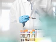 Scientifique vérifiant l'information sur les échantillons de sang prêts pour les essais cliniques en laboratoire — Photo de stock