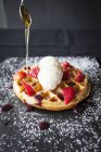 Colher derramando xarope de bordo sobre morangos e sorvete waffle — Fotografia de Stock