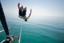 Человек, прыгающий головой в море — стоковое фото