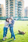 Portrait of mid adult couple with toddler daughter and dog in park — Stock Photo