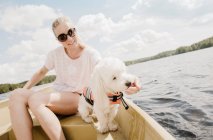 Женщина гладит котонную собаку на лодке, Оривеси, Финляндия — стоковое фото
