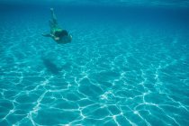 Vista submarina de la mujer nadando en el mar - foto de stock