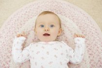 Porträt eines kleinen Mädchens auf Decke liegend, erhöhter Blick — Stockfoto