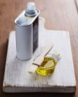 Tazón de aceite de oliva y cepillo de pastelería sobre tabla de cortar de madera - foto de stock