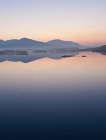 Montagne riflesse nel lago fermo durante il tramonto — Foto stock