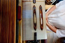 Молодая женщина использует ткацкий станок дома — стоковое фото