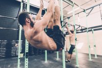 Jovens do sexo masculino cross trainer formação sobre anéis de exercício no ginásio — Fotografia de Stock