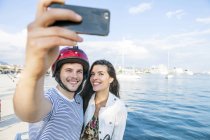 Jovem casal ciclomotor tomando selfie no porto, Split, Dalmácia, Croácia — Fotografia de Stock
