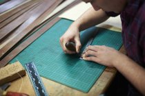 Trabajador masculino en taller de cuero, midiendo cuero, usando bradle - foto de stock