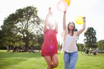 Дві молоді жінки танцюють з повітряними кулями на вечірці парку — стокове фото