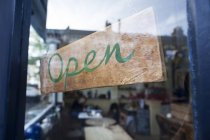 Schild an gläserner Cafétür geöffnet — Stockfoto