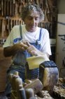 Carpintero con cincel en molde de madera para la cabeza en el taller - foto de stock