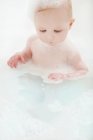 Bébé fille assis dans la baignoire — Photo de stock