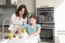 Mother and daughter washing dishes — Stock Photo