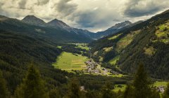 Landscape view of mountains and village under cloudy sky — Stock Photo