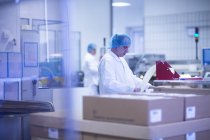 Arbeiter verpacken pharmazeutische Produkte am Fließband in pharmazeutischen Anlagen — Stockfoto