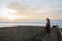 Женщины наслаждаются закатом на пляже — стоковое фото