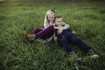 Fratello e sorella sdraiati insieme sull'erba — Foto stock