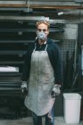 Портрет металлиста в пыльной маске в кузнице — стоковое фото