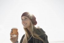 Jeune femme tenant une tasse de café par temps froid — Photo de stock