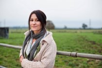Woman leaning on farm fence — Stock Photo